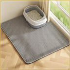 Cat litter mat on a wooden floor with a cat litter box containing cat litter.